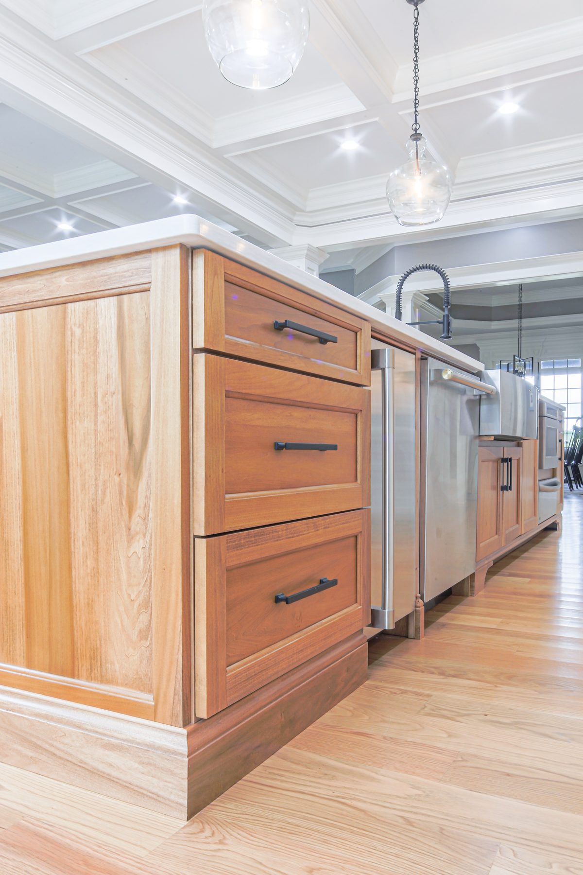 Stained hardwood island drawer bank with matte black hardware
