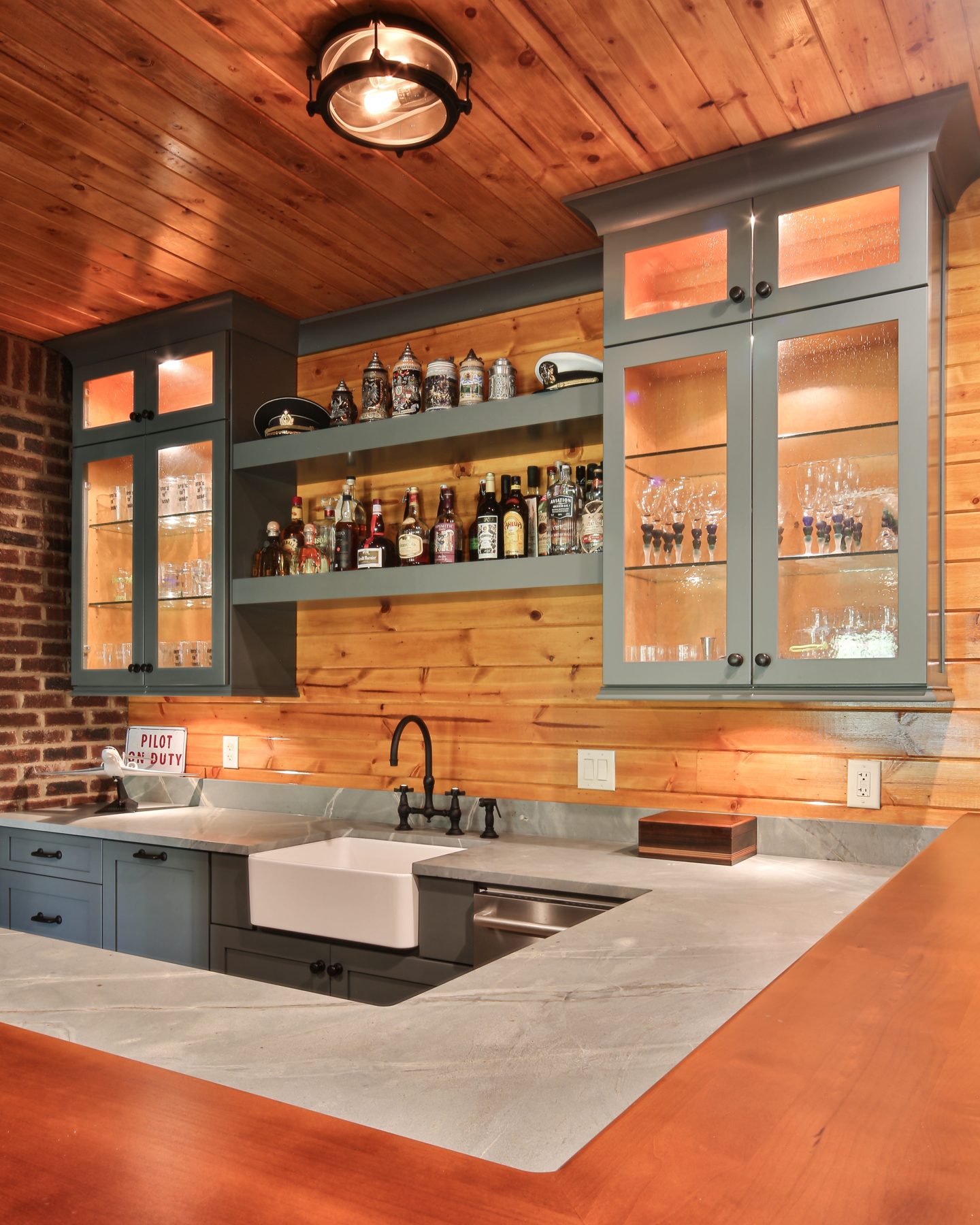 Wet bar with hammered copper counter and glass-front uppers