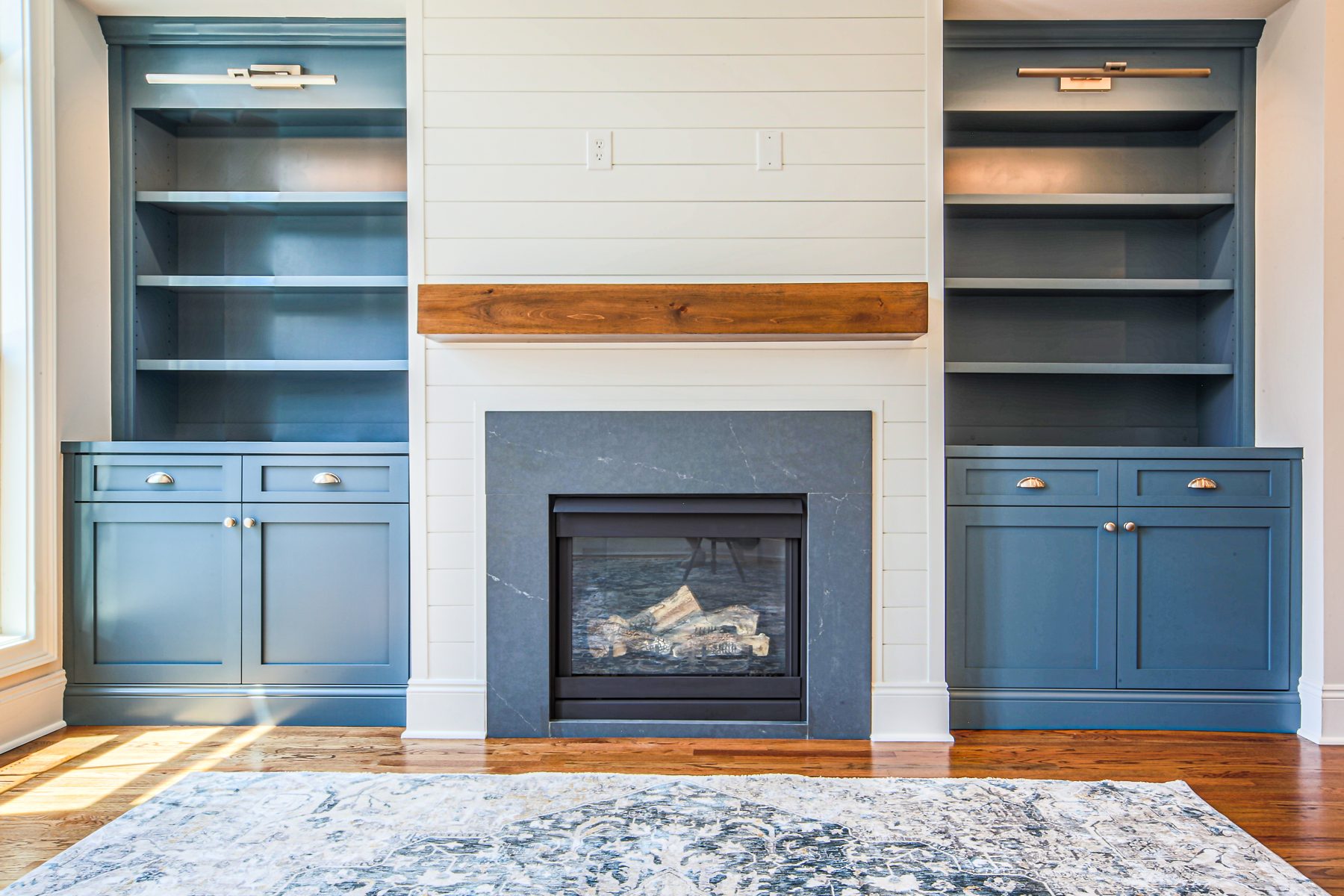 Painted blue built-in bookcases flanking a fireplace